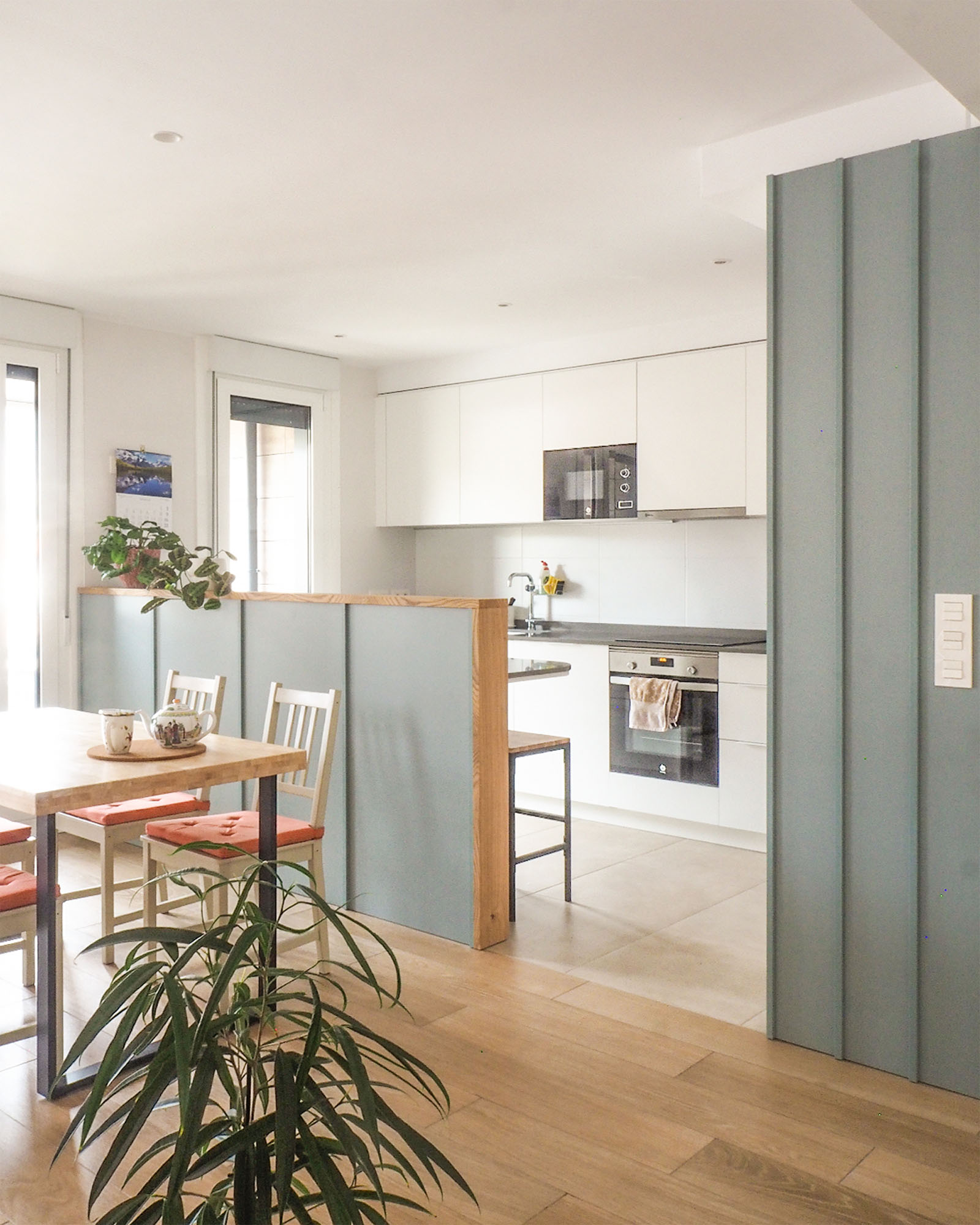 Reforma de vivienda juvenil, luminosa y colorida con cocina con barra hacia el comedor